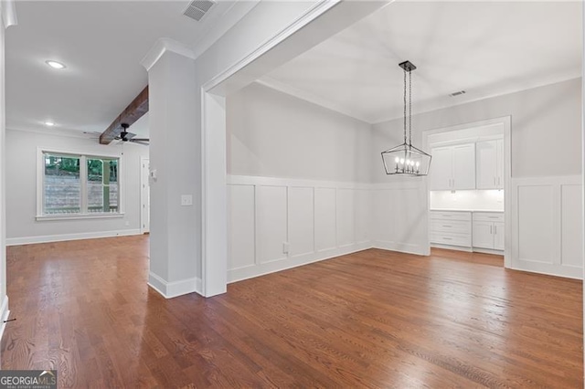 unfurnished dining area with ceiling fan with notable chandelier, beamed ceiling, hardwood / wood-style floors, and ornamental molding