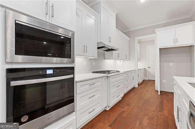 kitchen with appliances with stainless steel finishes, dark wood-type flooring, and white cabinetry