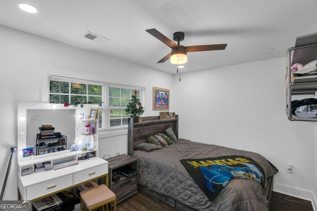 bedroom with dark hardwood / wood-style flooring and ceiling fan