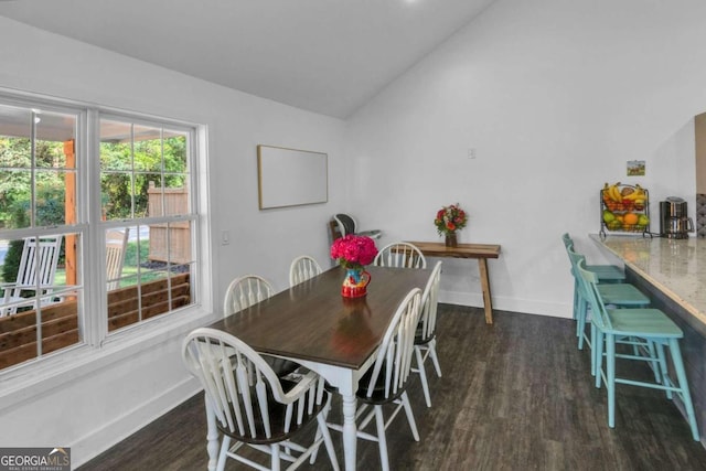 dining area with dark wood-type flooring and vaulted ceiling