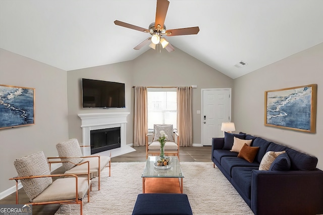 living room featuring light wood-type flooring, ceiling fan, and vaulted ceiling