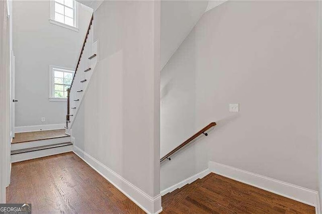 stairway featuring hardwood / wood-style flooring and a healthy amount of sunlight