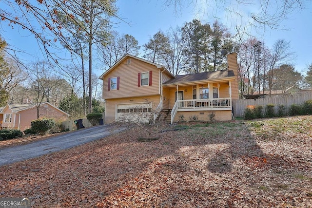 split level home featuring a garage and covered porch