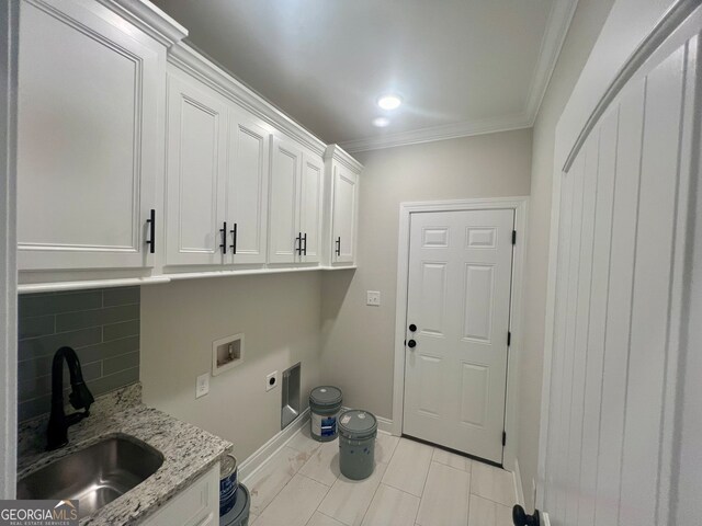 washroom with washer hookup, sink, hookup for an electric dryer, cabinets, and crown molding