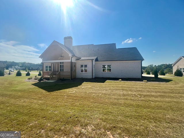 rear view of property featuring a lawn