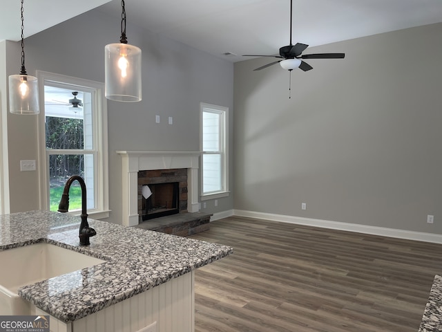 kitchen with pendant lighting, lofted ceiling, dark wood-type flooring, and sink