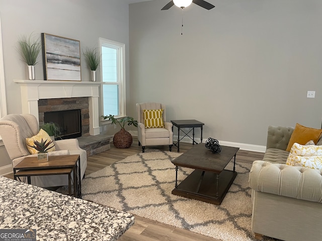 living room featuring ceiling fan, a fireplace, and hardwood / wood-style floors