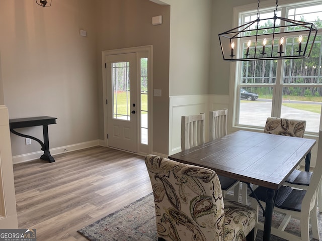 dining area featuring light hardwood / wood-style flooring, plenty of natural light, and a chandelier