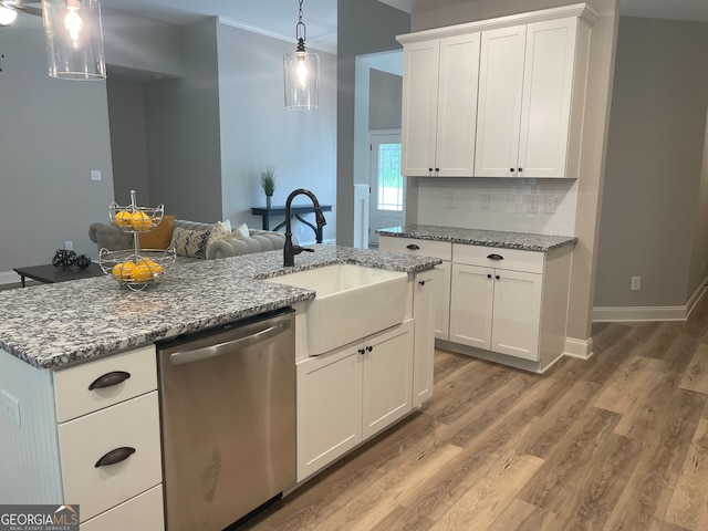 kitchen featuring stainless steel dishwasher, hardwood / wood-style flooring, sink, white cabinetry, and a center island with sink