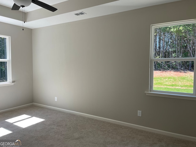 empty room with plenty of natural light, carpet flooring, and ceiling fan