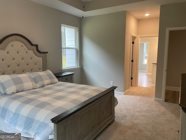 bedroom with light carpet and multiple windows