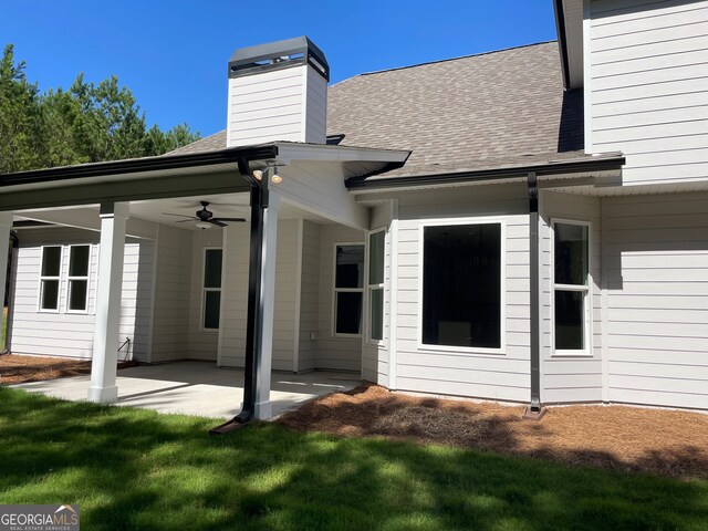 back of property with a patio, a yard, and ceiling fan