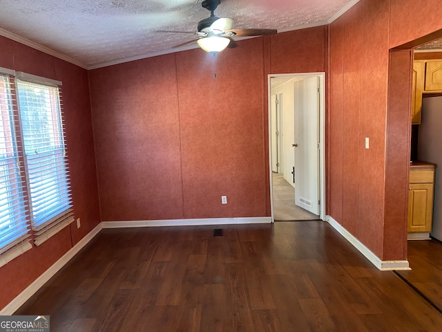 spare room featuring ceiling fan, dark hardwood / wood-style floors, crown molding, and a textured ceiling