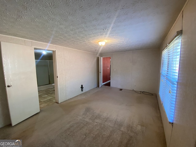 carpeted spare room featuring a textured ceiling