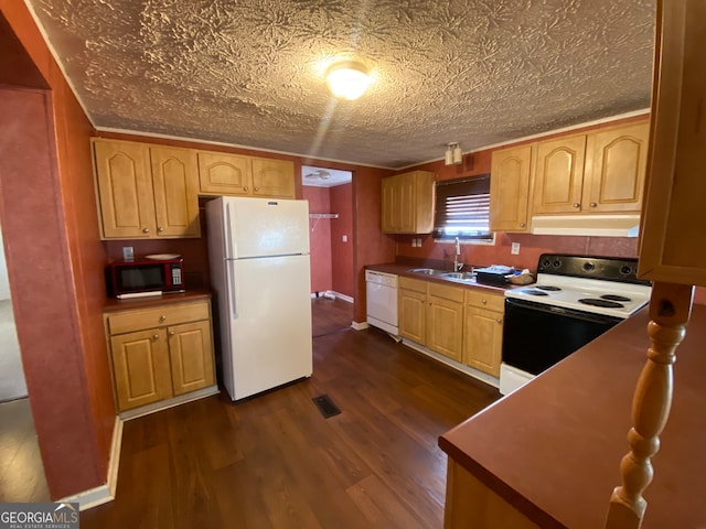 kitchen featuring white appliances, light brown cabinetry, dark hardwood / wood-style flooring, sink, and a textured ceiling