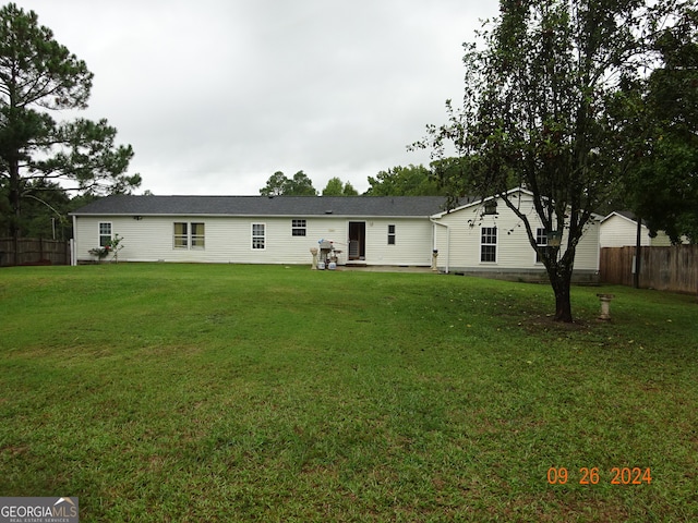 rear view of property featuring a yard