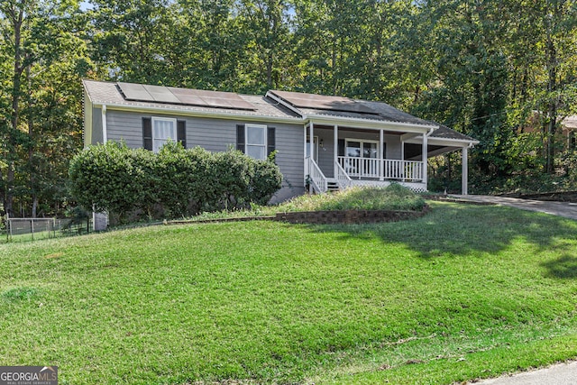 view of front of property with solar panels, a porch, and a front yard