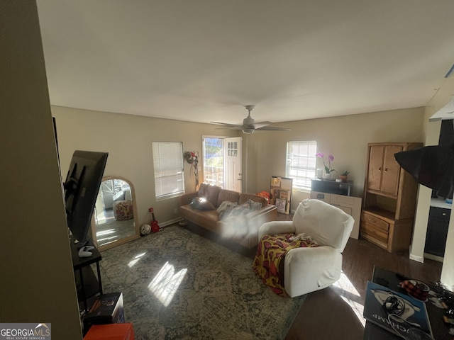 living room with dark wood-type flooring and ceiling fan