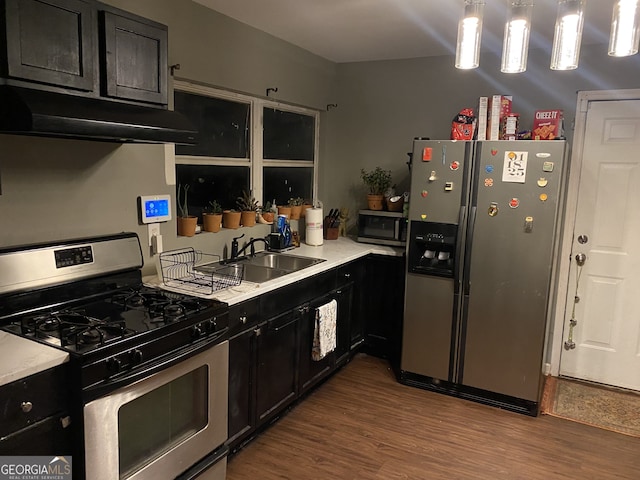 kitchen with sink, hardwood / wood-style floors, hanging light fixtures, and stainless steel appliances