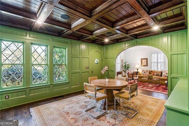 dining space with beam ceiling, coffered ceiling, dark wood-type flooring, and wooden ceiling