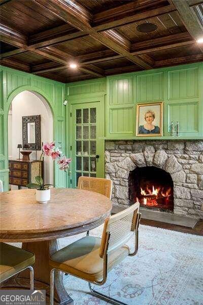 dining area with a fireplace, wood ceiling, coffered ceiling, and beam ceiling