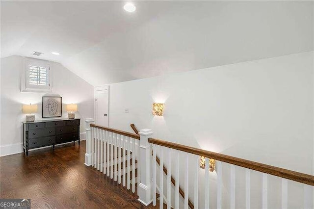 hallway featuring dark wood-type flooring and vaulted ceiling