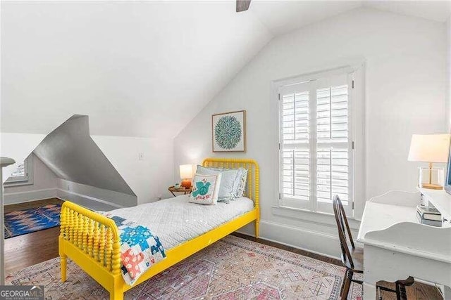 bedroom featuring hardwood / wood-style flooring, multiple windows, ceiling fan, and vaulted ceiling