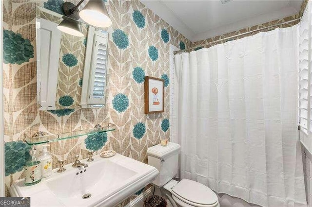 bathroom featuring sink, toilet, decorative backsplash, and curtained shower