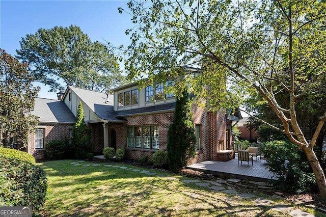 exterior space with a wooden deck and a lawn