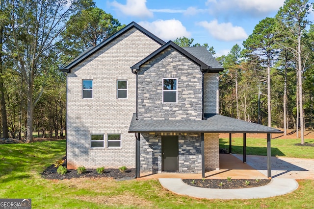 view of front of house with a front yard and a patio area