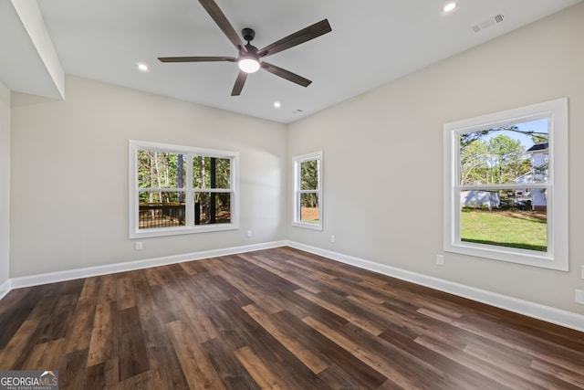 empty room featuring ceiling fan, plenty of natural light, and dark hardwood / wood-style floors