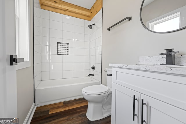 full bathroom with tiled shower / bath, vanity, hardwood / wood-style floors, and toilet