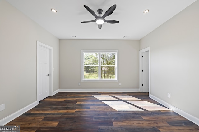 spare room with dark hardwood / wood-style flooring and ceiling fan