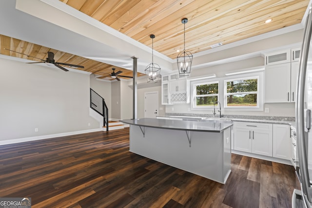 kitchen featuring a kitchen island, white cabinets, wooden ceiling, dark hardwood / wood-style flooring, and pendant lighting