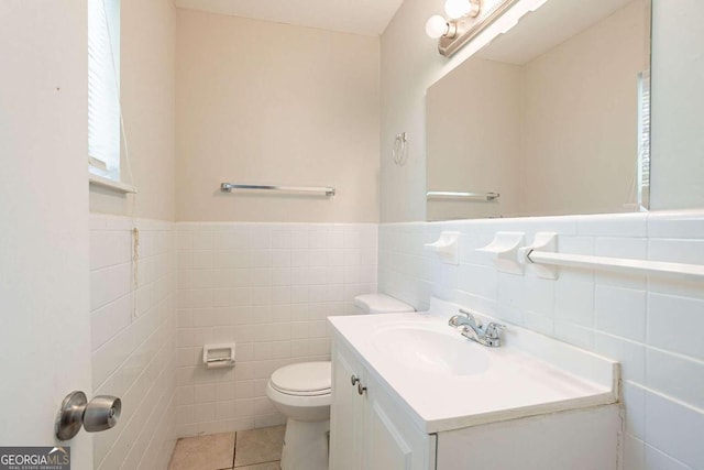 bathroom featuring tile patterned floors, vanity, tile walls, and toilet