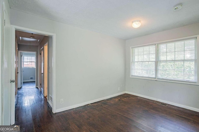 unfurnished room featuring dark hardwood / wood-style flooring and a textured ceiling