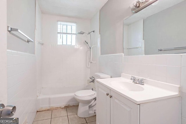 full bathroom featuring tiled shower / bath combo, tile patterned flooring, toilet, vanity, and tile walls