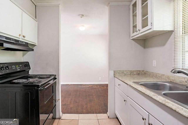 kitchen featuring black range with electric stovetop, sink, white cabinets, and light hardwood / wood-style flooring