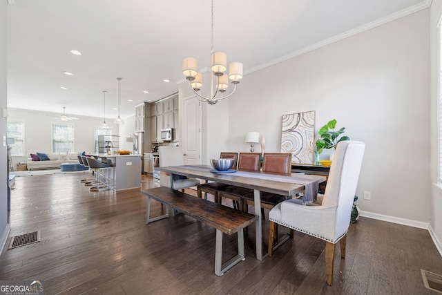 dining room with a chandelier, crown molding, and dark hardwood / wood-style flooring