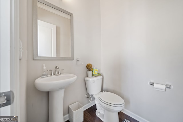 bathroom with wood-type flooring, sink, and toilet