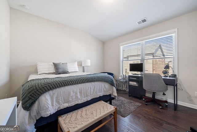 bedroom featuring dark wood-type flooring and vaulted ceiling