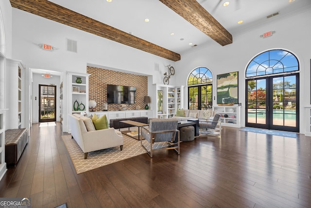 living room with a high ceiling, beam ceiling, french doors, and dark hardwood / wood-style flooring