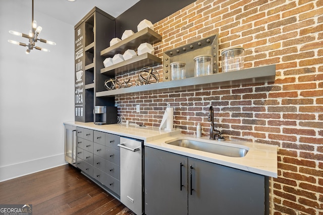 kitchen with a notable chandelier, sink, dark hardwood / wood-style flooring, and gray cabinetry