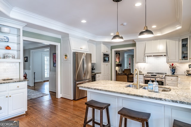 kitchen featuring premium range hood, dark hardwood / wood-style floors, light stone countertops, appliances with stainless steel finishes, and white cabinetry