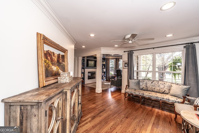 living room with dark hardwood / wood-style floors, ceiling fan, and ornamental molding