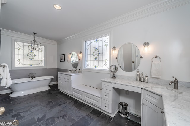 bathroom featuring a chandelier, vanity, a tub to relax in, and ornamental molding