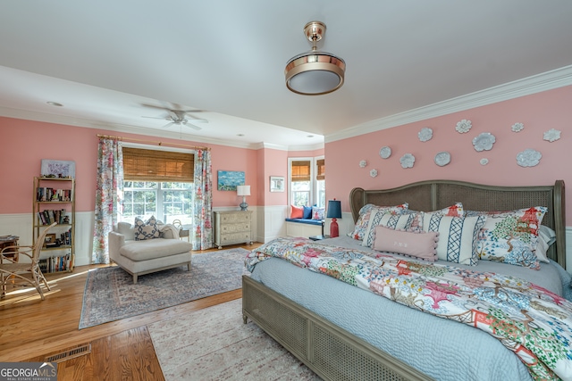 bedroom featuring light wood-type flooring, ceiling fan, and ornamental molding