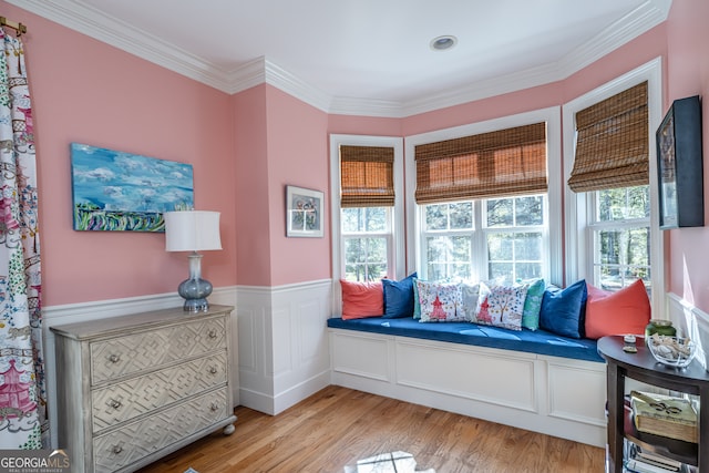 living area featuring crown molding and light hardwood / wood-style flooring