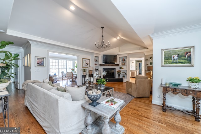 living room with built in shelves, a notable chandelier, crown molding, wood-type flooring, and vaulted ceiling