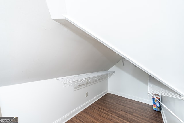 spacious closet with dark hardwood / wood-style flooring and lofted ceiling